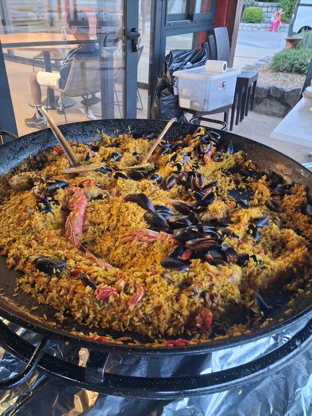 Paella géante aux moules et gambas en cours de cuisson